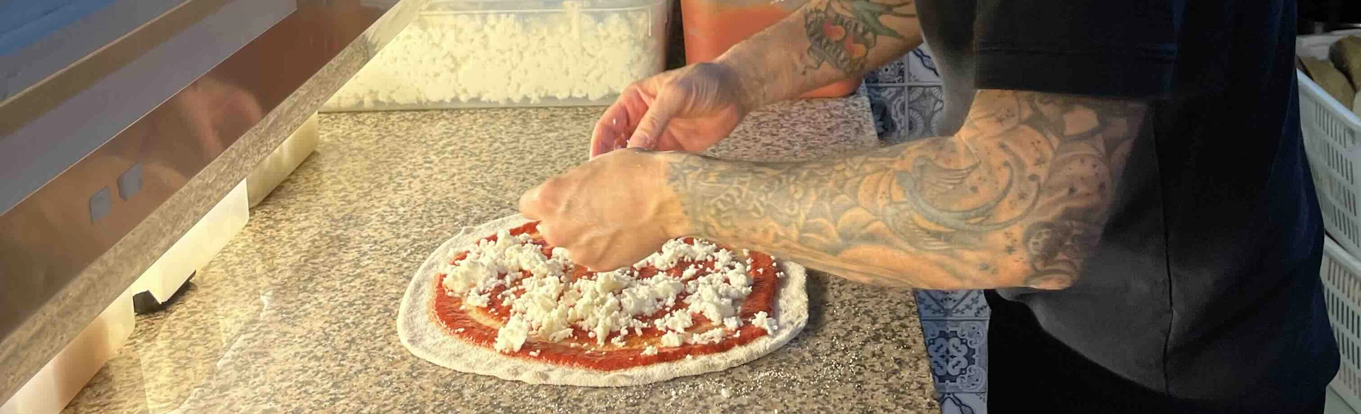 Pizzaiolo prepara una pizza gourmet nella pizzeria The Little Italy a San Maurizio Canavese